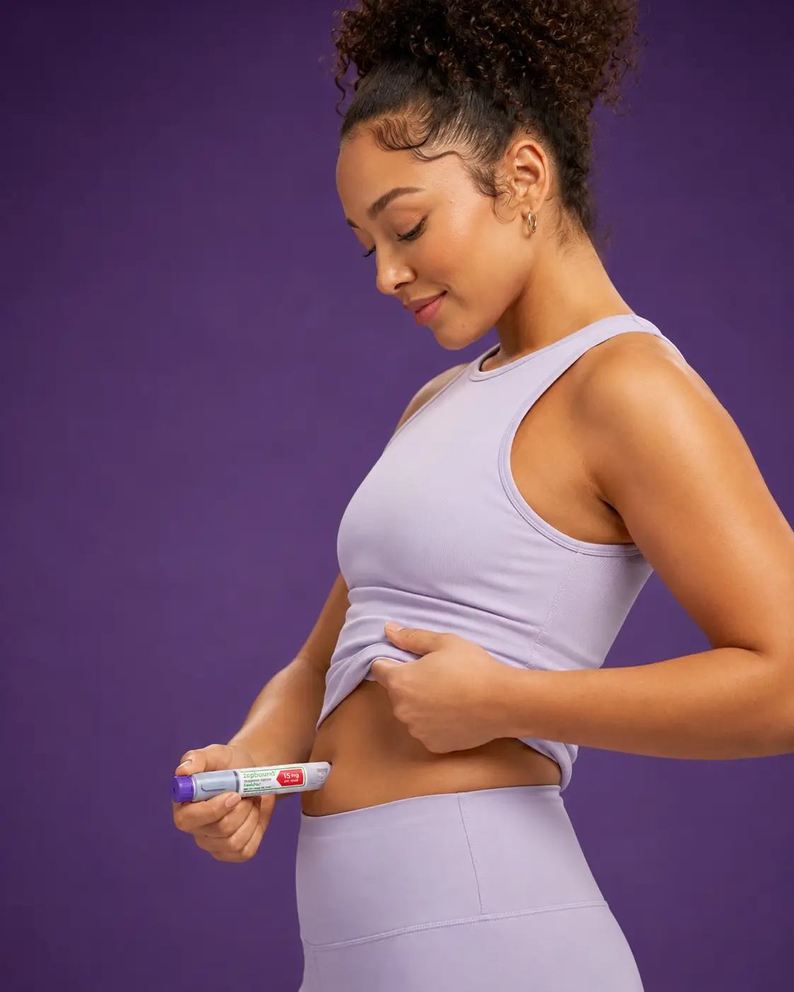 Woman in lavender activewear holding a Zepbound single-dose pen before her weekly injection